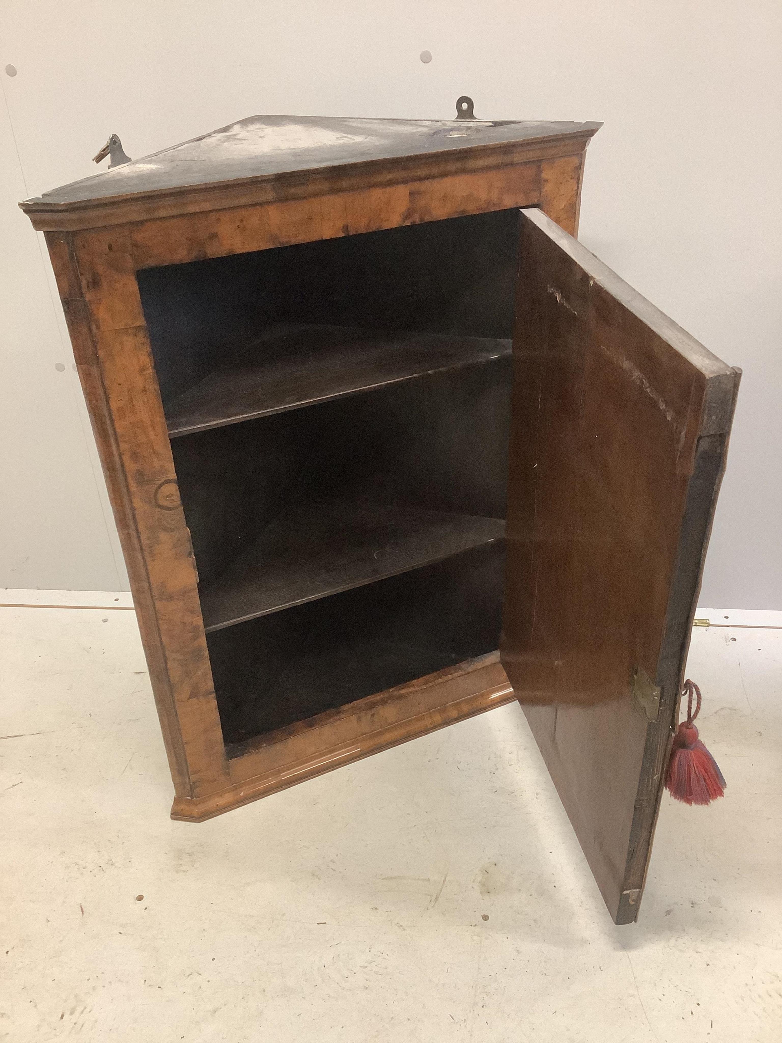 An 18th century banded walnut hanging corner cupboard, width 64cm, depth 32cm, height 83cm. Condition - fair